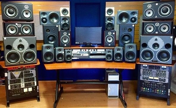 Audio-visual editing setup with monitor, speakers, and rack equipment